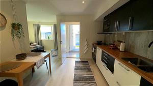 a kitchen with a table and a living room at Bardufoss Panorama in Bardufoss