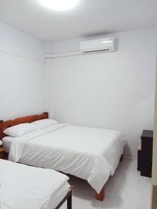 Ένα ή περισσότερα κρεβάτια σε δωμάτιο στο ปุญญพัฒน์ โฮมสเตย์