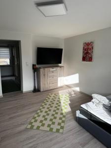 Una sala de estar con un televisor de pantalla plana y un sofá. en Zum Herold, en Thale