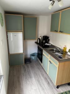 Una pequeña cocina con fregadero y refrigerador. en Zum Herold, en Thale
