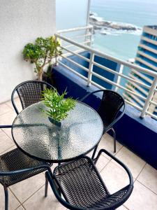 a glass table and chairs on a balcony at Departamento arriendo remodelado in Viña del Mar