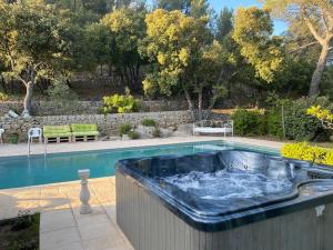 a swimming pool with a hot tub with water at LA BASTIDETTE PROVENçALE in Jouques