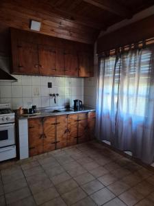 a kitchen with wooden cabinets and a stove top oven at La Casa De Yayo in San Luis +16 photos