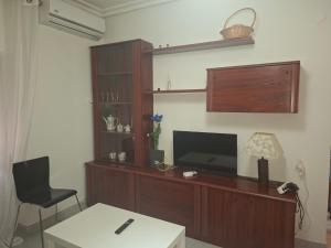 sala de estar con TV, mesa y silla en Confortable piso en Puertollano, en Puertollano