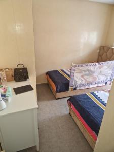 apartement avec piscine résidence sécurisée meublé confort jnan dalia Boznika في بن سليمان: غرفة صغيرة بها سريرين ومكتب +13 صورة