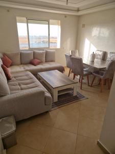 apartement avec piscine résidence sécurisée meublé confort jnan dalia Boznika في بن سليمان: غرفة معيشة مع أريكة وطاولة