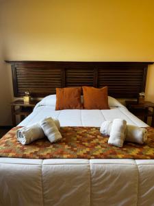 a large white bed with three pillows on it at Patagonia Austral Suites - Cabaña con servicio de hotel - DESAYUNO INCLUIDO! in El Calafate