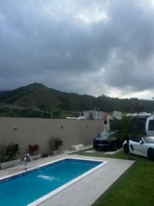 una piscina con auto parcheggiata accanto a una casa di Enseada Beach a São Sebastião 1 altra foto