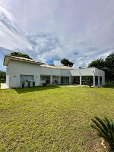 a large white building with a large grass yard at Chácara Segredo in Bonito +17 photos