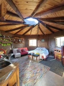 a living room with a bed and a couch at Refugio de tierra con vistas en Ocoa in Viña Guzmán