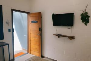 a room with a door and a television on a wall at Casinhas Terõ - in Boracéia