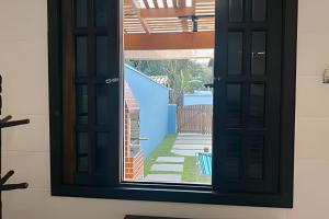 a window with a view of a house at Casinhas Terõ - in Boracéia