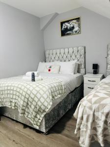 a bedroom with a large bed with a headboard at Heathrow roomzzzz BnB in Hayes