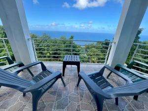 un portico con due sedie e un tavolo e l'oceano di Abigail's Esmeralda 2 bedrom Apt a Tortola Island