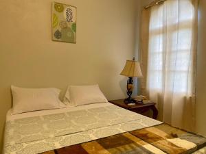 una camera da letto con un letto, una lampada e una finestra di Abigail's Esmeralda 2 bedrom Apt a Tortola Island