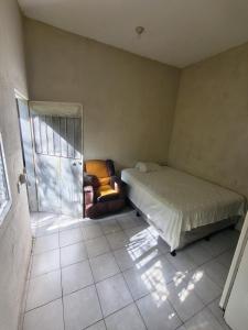 a bedroom with a bed and a chair in it at Apartamentos Emanuel in San Benito