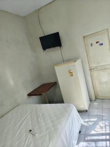 a room with a bed and a refrigerator and a table at Apartamentos Emanuel in San Benito +3 photos