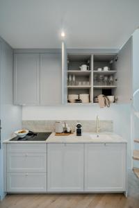 a kitchen with white cabinets and a sink at Zegrze Lake Apartament przy Narwi LEKKO z sauną in Zegrze