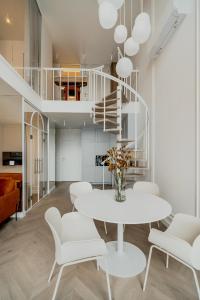 a dining room with a white table and chairs at Zegrze Lake Apartament przy Narwi LEKKO z sauną in Zegrze