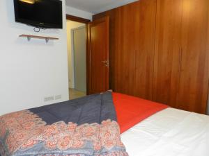 Schlafzimmer mit einem Bett und einem TV an der Wand in der Unterkunft CASA ELENA 1 in Germignaga