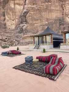 a group of pillows on a rug in the desert at Wadi Rum Bubbles Wissam camp in Wadi Rum +70 photos