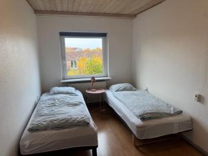 Cozy Apartment in Billund في بيلوند: سريرين في غرفة بها نافذة