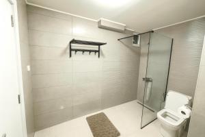een badkamer met toilet en glazen douche bij Vodno Apartment - Top location and private parking in Skopje +8 foto's