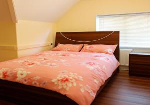 a bedroom with a bed with pink flowers on it at SS Sunrise & Silk in Bersted