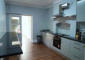a kitchen with blue walls and stainless steel appliances at SS Sunrise & Silk in Bersted