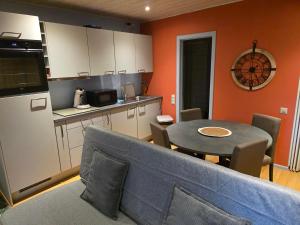 a kitchen with a couch and a table in a room at Le Rouge Gorge Curieux in Vresse-sur-Semois