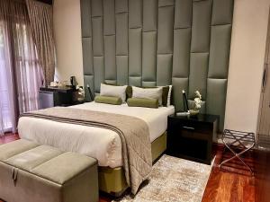 a bedroom with a large bed with a padded wall at One O Eight Boutique Hotel in Benoni +29 photos