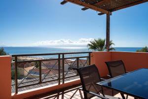 a balcony with a table and chairs and the beach at Mounda Beach Retreat in Skala +274 photos