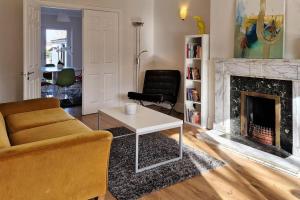 a living room with a couch and a fireplace at 2 minute walk to LUAS (tram) in Dublin +7 photos