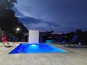 a swimming pool at night with chairs around it at Casa Chika, Playa Grande, Private House, Pool, Kitchen, AC in Cuajiniquil