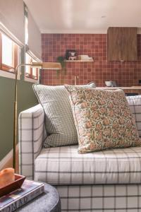 Avoca Studio في ريتشموند: أريكة عليها وسادة في غرفة المعيشة +3 صور