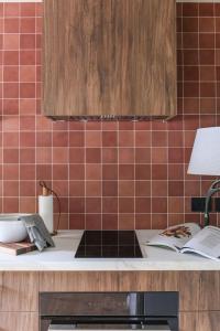 Avoca Studio في ريتشموند: مطبخ بجدران حمراء البلاط وقمه منضده