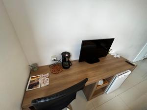 a desk with a computer and a monitor on it at Apartamentos no Verano Stay in Rio de Janeiro
