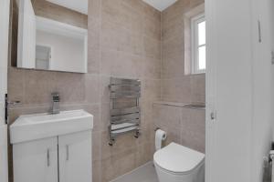a bathroom with a toilet and a sink and a mirror at Modern 3 BR House near Bicester Village in Bicester +8 photos