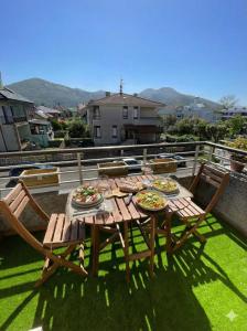 a wooden table with two plates of food on a patio at Paraíso de Berria frente al Mar in Santoña