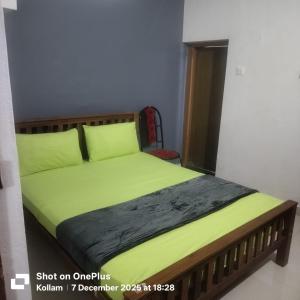 コーラムにあるSunny's Holiday Homesの緑色のベッドカバーと枕が備わる客室のベッド1台分です。