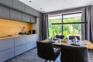 Ski-in Ski out Luxury Apartment في روسباخ أم باس غشوت: مطبخ وغرفة طعام مع طاولة وكراسي