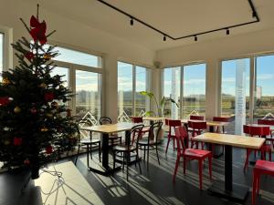 a christmas tree in a restaurant with tables and chairs at Pokoje Dębowa Góra in Kłobuck