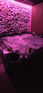 a room with a hot tub with two wine glasses at Instant Evasion in Châtelet