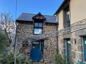 ein altes Steinhaus mit blauer Tür in der Unterkunft Chambre à la campagne in Québriac + 15 Fotos