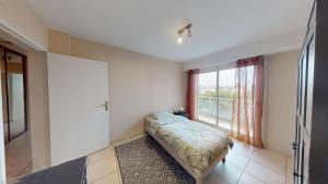 ein Schlafzimmer mit einem Bett und einem großen Fenster in der Unterkunft Djimmy hébergement in Saint-Herblain