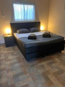 Apartments & Wellness Diva في Sint Jozefsdal: غرفة نوم عليها سرير وعليها شنطتين