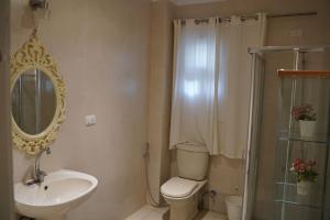 a bathroom with a toilet and a sink and a mirror at Garden Home in Sheikh Zayed