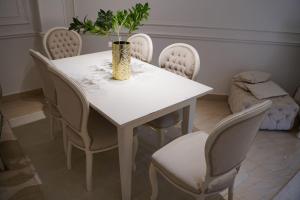 a white table with chairs and a vase with a plant at Garden Home in Sheikh Zayed +13 photos