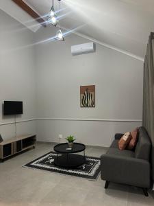 een woonkamer met een bank en een tafel bij Pendleberry Grove 33 in Bela-Bela