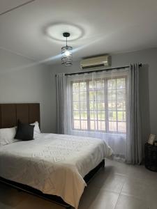 een slaapkamer met een groot bed en een raam bij Pendleberry Grove 33 in Bela-Bela +14 foto's